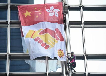 lo Spiderman francese scala un grattacielo e mostra la bandiera per la pace