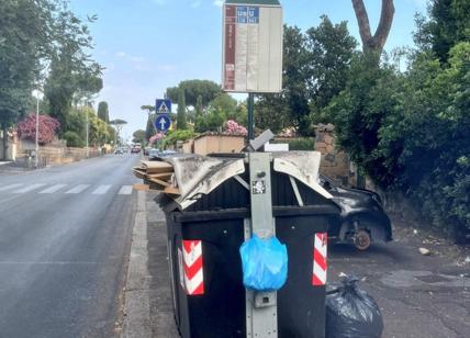 Cartolina da Roma: fermata del bus con immondizia e un'auto con ruote rubate