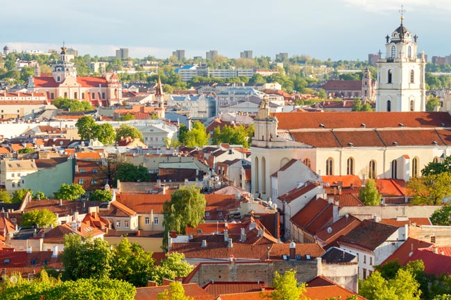 Vilnius, piccola capitale della Lituania, raccoglie da più di vent’anni scrittori, artisti e intellettuali da ogni parte del mondo. Città eclettica immersa nel verde con il centro storico in stile barocco con numerosi palazzi e chiese, dichiarato Patrimonio dell’Umanità dell’Unesco. L’occasione ideale per visitare la città è durante la Fiera di San Casimiro, che prende il nome del santo patrono della città. Una sagra popolare dove artisti e venditori si riuniscono presso il centro storico della città offrendo ai passanti creazioni artigianali, spettacoli, birra, vino, cibo caldo e biscotti al miele a forma di cuore. Vilnius, piccola capitale della Lituania, raccoglie da più di vent’anni scrittori, artisti e intellettuali da ogni parte del mondo. Città eclettica immersa nel verde con il centro storico in stile barocco con numerosi palazzi e chiese, dichiarato Patrimonio dell’Umanità dell’Unesco. L’occasione ideale per visitare la città è durante la Fiera di San Casimiro, che prende il nome del santo patrono della città. Una sagra popolare dove artisti e venditori si riuniscono presso il centro storico della città offrendo ai passanti creazioni artigianali, spettacoli, birra, vino, cibo caldo e biscotti al miele a forma di cuore.
