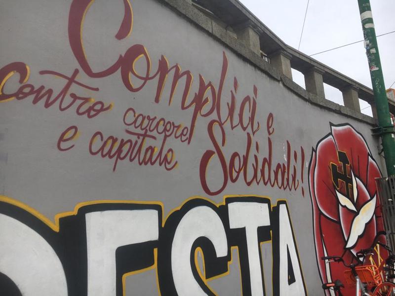 "La lotta non si arresta - Complici e solidali contro carcere e capitale". Non è stato ancora rimosso il mega murale in onore di Dax in Darsena: come ogni anno, nell'anniversario del suo assassinio per mano dei fratelli Federico e Mattia Morbi e del padre Giorgio, il coordinamento Memoria Antifascista ed il centro sociali di Milano sfilano il 16 marzo. E come ogni anno viene realizzato in Darsena un murale in ricordo di Davide Cesare, morto nel 2003 dopo l'aggressione all'esterno di un bar in via Brioschi. L'anno scorso la cancellazione dei murales era avvenuta a pochi giorni di distanza dalla loro comparsa. (foto: Claudio Bernieri)
