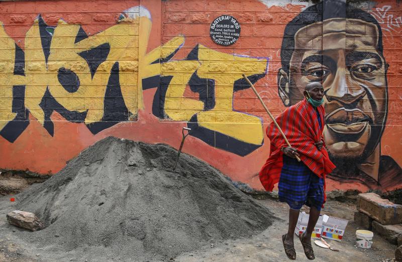 Masai davanti a un murale che raffigura Floyd e la scritta "giustizia" nello slum di Kibera, a Nairobi
