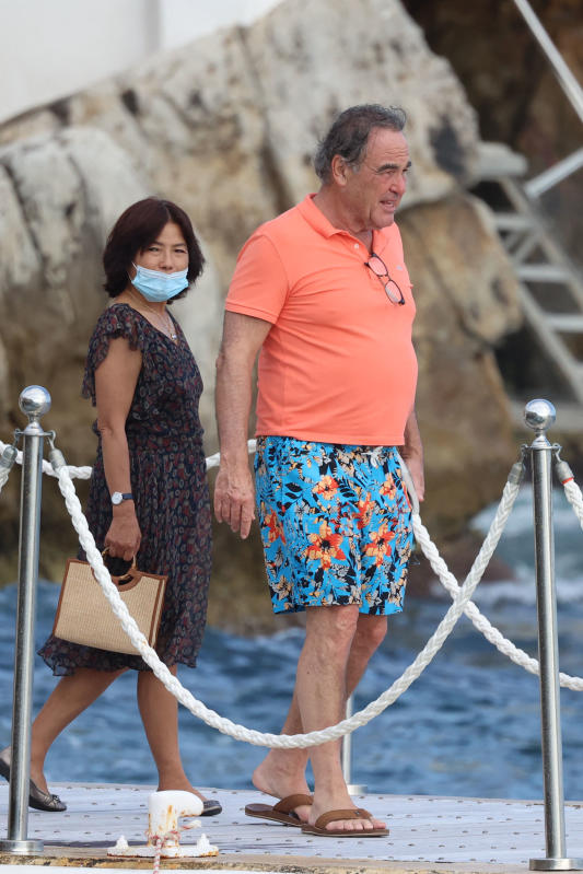 Antibes, Oliver Stone in costume a fiori e infradito cerca di salire in barca