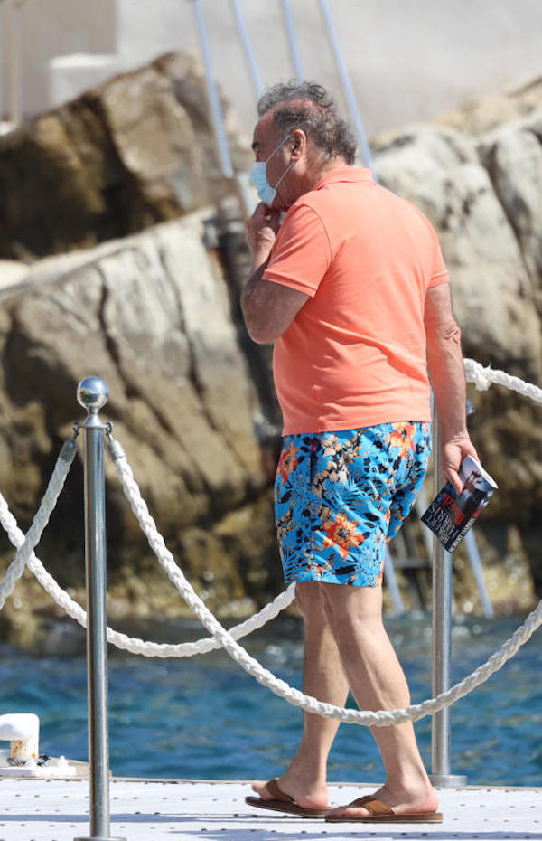 Antibes, Oliver Stone in costume a fiori e infradito cerca di salire in barca
