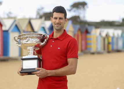 Australian Open, trionfo di Novak Djokovic, in spiaggia con il trofeo