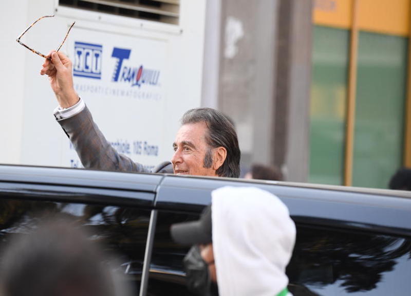 Roma , Lady Gaga esce scortata da una guardia del corpo nacsondendosi dietro una borsetta mentre Al Pacino saluta I fan al termine delle riprese del film “house of Gucci “ ipa