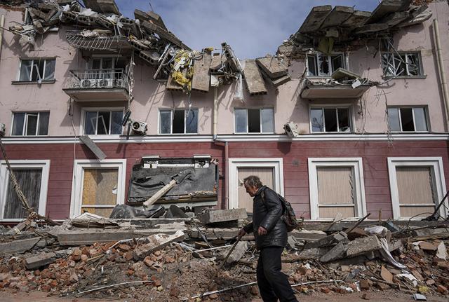 Un uomo passa davanti a un edificio danneggiato dai bombardamenti a Chernihiv, Un uomo passa davanti a un edificio danneggiato dai bombardamenti a Chernihiv,