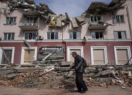 Un uomo passa davanti a un edificio danneggiato dai bombardamenti a Chernihiv,