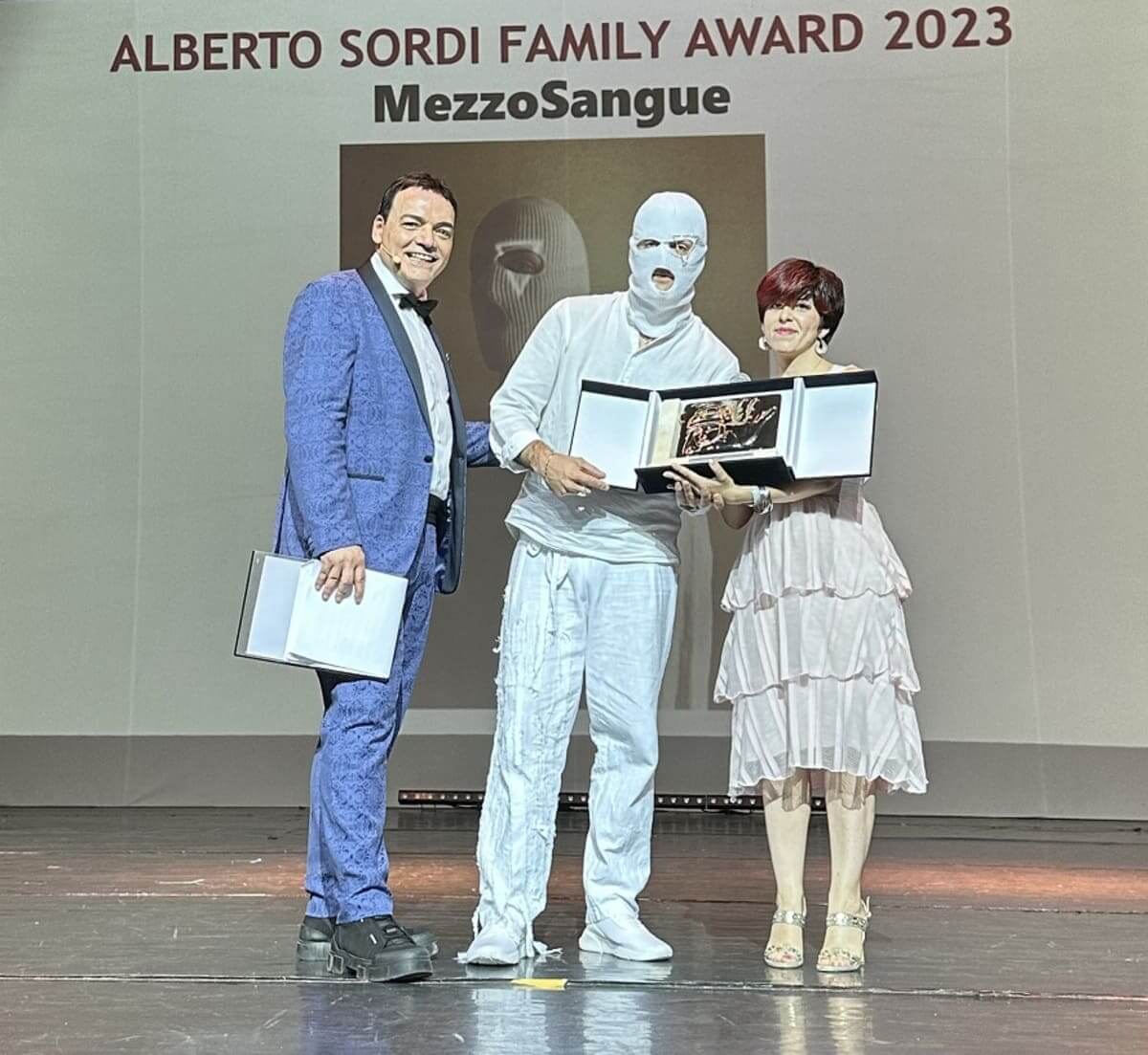 Il rapper MezzoSangue riceve il Premio da Righetti e dalla direttrice di Cinematographe.it Teresa Monaco.jpg Il rapper MezzoSangue riceve il Premio da Righetti e dalla direttrice di Cinematographe.it Teresa Monaco.jpg