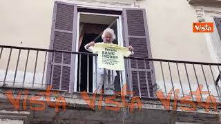 Beppe Grillo mostra una maglietta dal balcone della sede romana del Movimento 5 Stelle