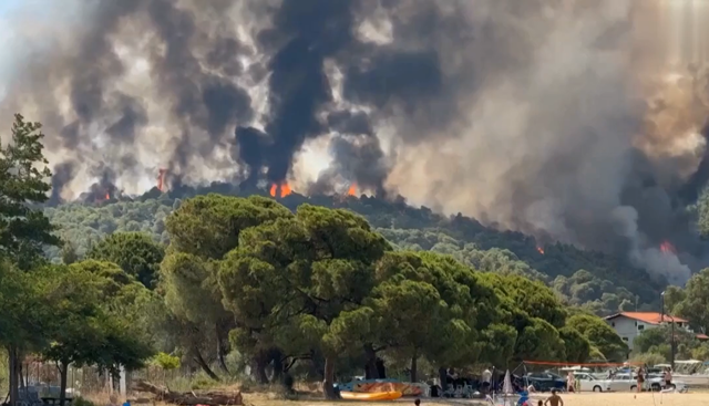 Caldo record e gli incendi devastano Creta, i bagnanti terrorizzati scappano dalla spiaggia