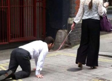Donna cammina con un uomo al guinzaglio. Le foto