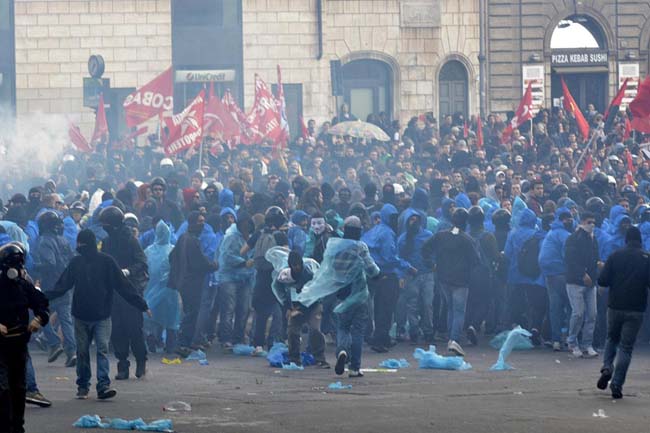 Agente calpesta una ragazza a terra. Foto e video degli scontri a Roma Agente calpesta una ragazza a terra. Foto e video degli scontri a Roma