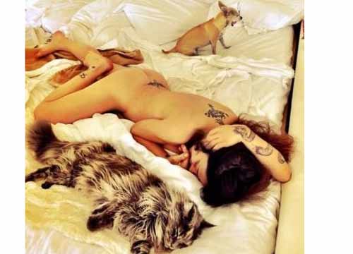 Naike nuda tra le lenzuola con cane e gatto