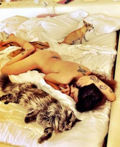 Naike nuda tra le lenzuola con cane e gatto