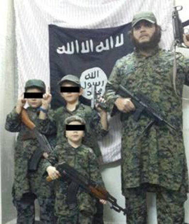 Siria choc: un bimbo mostra la testa mozzata di un soldato. Foto