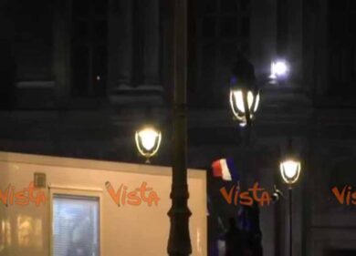 Ragazzo si arrampica su un lampione per festeggiare la vittoria di Macron