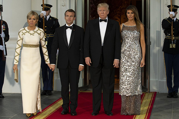 Melania Trump: cappello, abito Dior, paillettes. Così ruba la scena a Brigitte Melania Trump: cappello, abito Dior, paillettes. Così ruba la scena a Brigitte