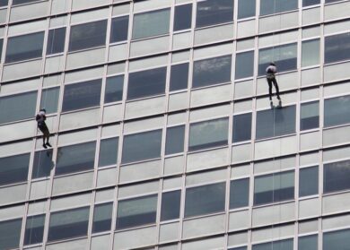 Caritas, flash mob anti-razzista: due scalatori sul Pirellone. FOTO