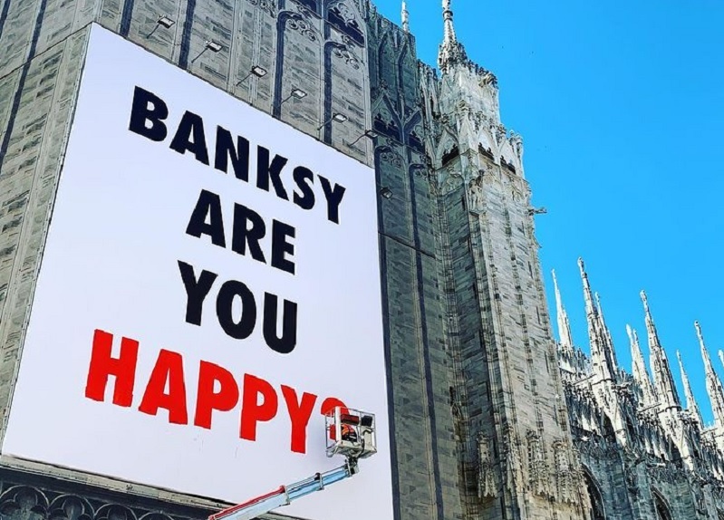 Milano, sul Duomo spunta un maxi poster con il nome di Banksy Milano, sul Duomo spunta un maxi poster con il nome di Banksy