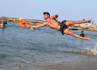 Ragazzo gioca a racchettoni sulla spiaggia