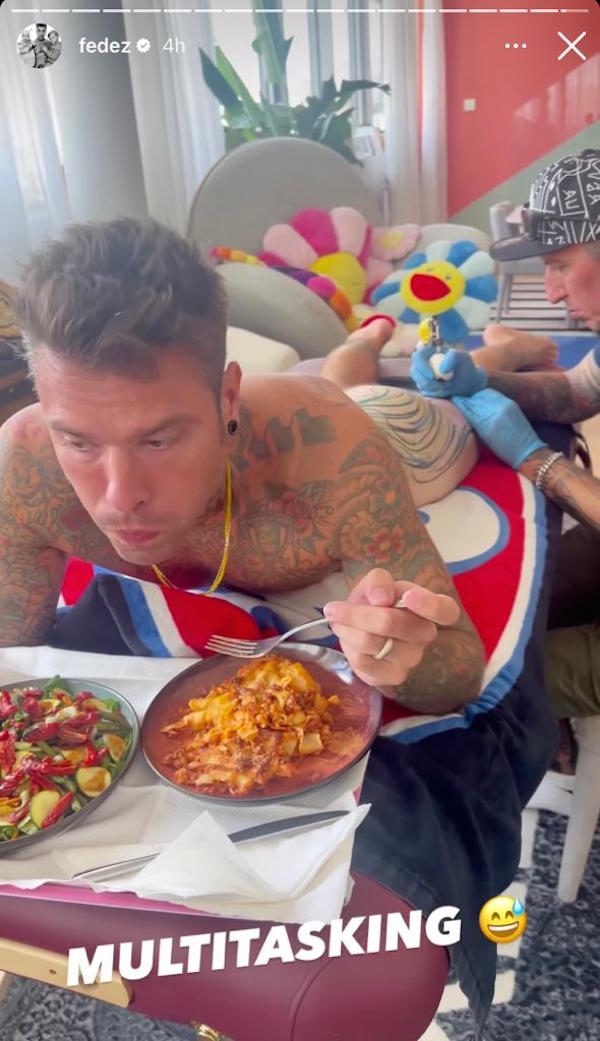 Fedez mentre si tatua la schiena, il sedere e la gamba mangia lasagne