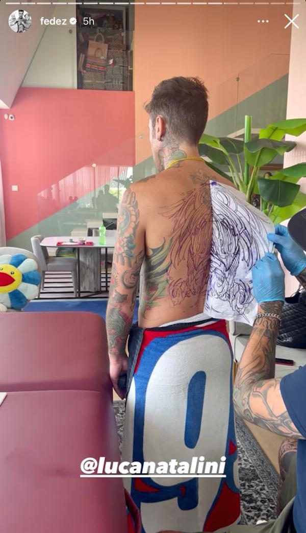 Fedez mentre si tatua la schiena, il sedere e la gamba mangia lasagne
