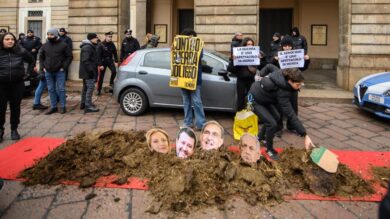 Prima della Scala, letame sul tappeto rosso: il flashmob di protesta con i volti di Meloni e Salvini |VIDEO