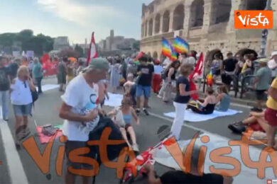 Corteo a Roma contro il riarmo, il sit in con i lenzuoli bianchi davanti al Colosseo. Netanyahu dietro le sbarra e ‘Fuori guerra dalla storia’, i cartelli  – VIDEO