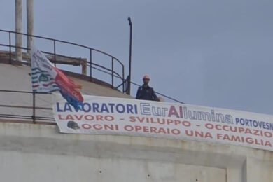 Eurallumina e crisi industriale nel Sulcis (Sardegna), operai su un silo a 40 metri d’altezza: “Il Mimit ci convochi”