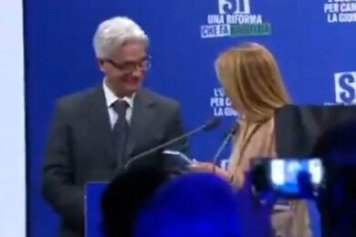 Meloni senza parole, a sorpresa un uomo sale sul palco e le consegna un libro